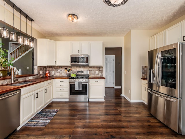 299 Stonhope Dr, Delaware, OH 43015 - kitchen featuring appliances with stainless steel finishes, wood counters, tasteful backsplash, dark wood finished floors, and a textured ceiling