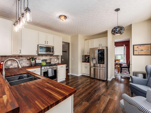 299 Stonhope Dr, Delaware, OH 43015 - kitchen with wooden counters, stainless steel appliances, tasteful backsplash, dark wood-style floors, and a textured ceiling