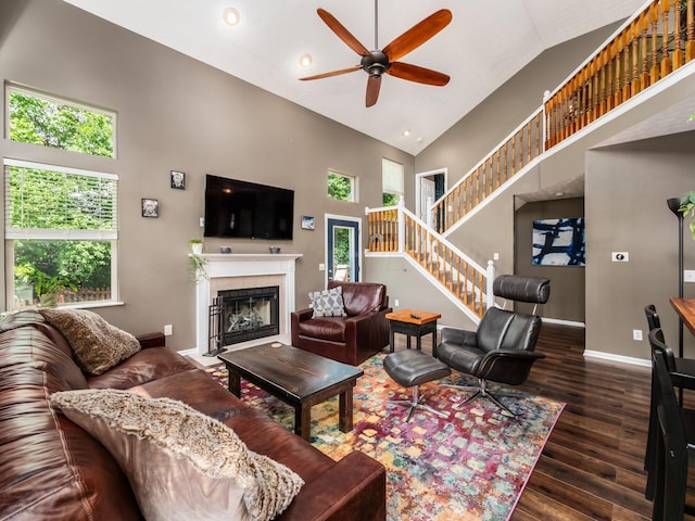 299 Stonhope Dr, Delaware, OH 43015 - living room with high vaulted ceiling, a ceiling fan, stairs, a fireplace with flush hearth, and wood finished floors
