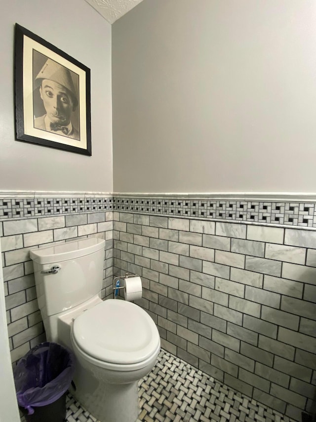299 Stonhope Dr, Delaware, OH 43015 - bathroom featuring a wainscoted wall, tile walls, and tile patterned floors