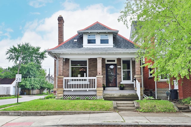 459 E Whittier St, Columbus, OH 43206 - view of front facade with a porch, a shingled roof, a chimney, a front lawn, and brick siding