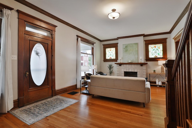 459 E Whittier St, Columbus, OH 43206 - entryway featuring light wood-style floors, crown molding, a tile fireplace, and baseboards