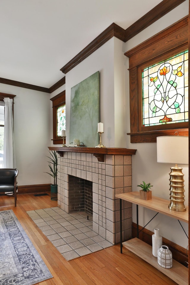 459 E Whittier St, Columbus, OH 43206 - living room with crown molding, wood finished floors, baseboards, and a tile fireplace