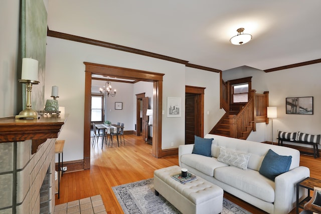 459 E Whittier St, Columbus, OH 43206 - living area with a chandelier, crown molding, light wood-type flooring, stairs, and baseboards