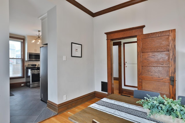 459 E Whittier St, Columbus, OH 43206 - entryway featuring baseboards, ornamental molding, wood finished floors, and a chandelier