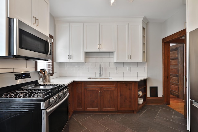 459 E Whittier St, Columbus, OH 43206 - kitchen featuring stainless steel appliances, a sink, open shelves, and light countertops
