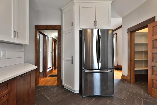 459 E Whittier St, Columbus, OH 43206 - kitchen with freestanding refrigerator, white cabinets, dark tile patterned flooring, and light countertops