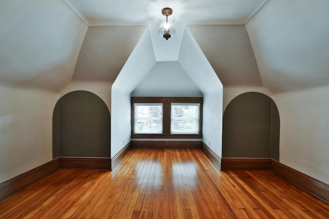 459 E Whittier St, Columbus, OH 43206 - additional living space with hardwood / wood-style flooring, arched walkways, baseboards, and lofted ceiling