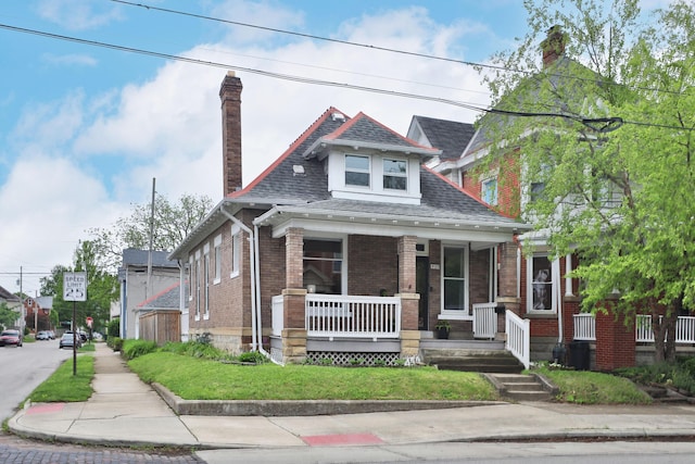 459 E Whittier St, Columbus, OH 43206 - bungalow with covered porch, a chimney, brick siding, and roof with shingles