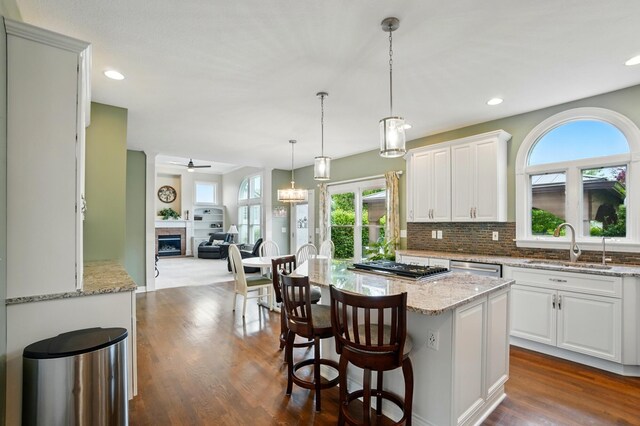 6467 Spring Run Dr, Westerville, OH 43082 - kitchen with a sink, appliances with stainless steel finishes, a ceiling fan, a fireplace, and light stone countertops
