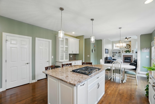 6467 Spring Run Dr, Westerville, OH 43082 - kitchen with stainless steel gas cooktop, white cabinetry, dark wood-style flooring, glass insert cabinets, and a center island