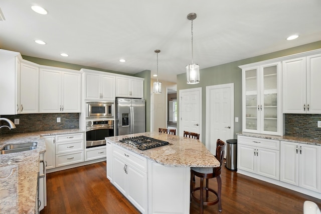 6467 Spring Run Dr, Westerville, OH 43082 - kitchen with stainless steel appliances, a sink, decorative backsplash, white cabinets, and a breakfast bar area