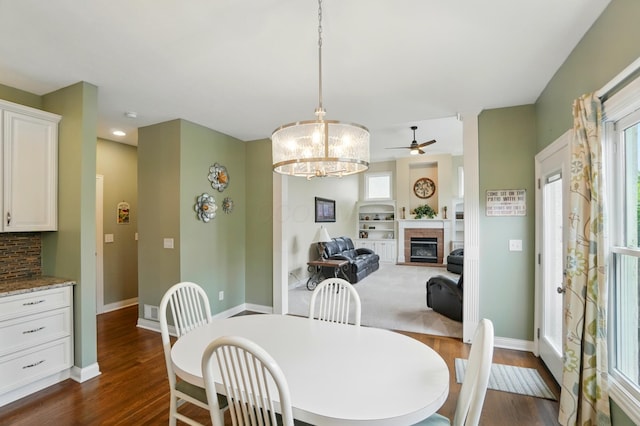 6467 Spring Run Dr, Westerville, OH 43082 - dining area featuring dark wood-style floors, a ceiling fan, a glass covered fireplace, and baseboards