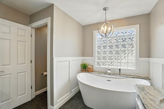 6467 Spring Run Dr, Westerville, OH 43082 - full bathroom featuring wainscoting, a decorative wall, a chandelier, and a freestanding bath