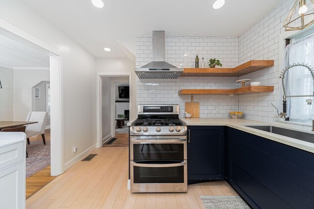 1272 Broadview Ave, Columbus, OH 43212 - kitchen featuring range with two ovens, wall chimney exhaust hood, a sink, light countertops, and tasteful backsplash