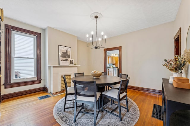 1057 Harrison Ave, Columbus, OH 43201 - dining room featuring a chandelier, plenty of natural light, and light wood-style floors