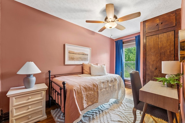 1057 Harrison Ave, Columbus, OH 43201 - bedroom featuring wood finished floors, a textured ceiling, and a ceiling fan