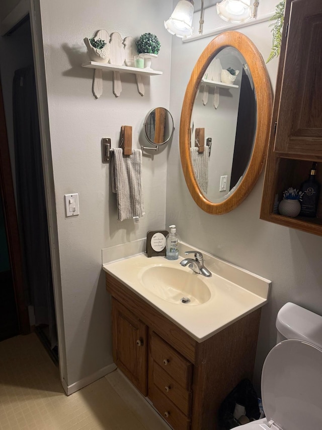half bath featuring vanity and toilet