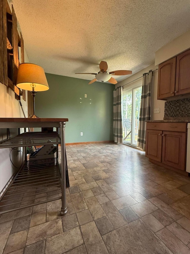 2836 Palisades Ave, Columbus, OH 43207 - kitchen with stone tile flooring, ceiling fan, a textured ceiling, and dark countertops