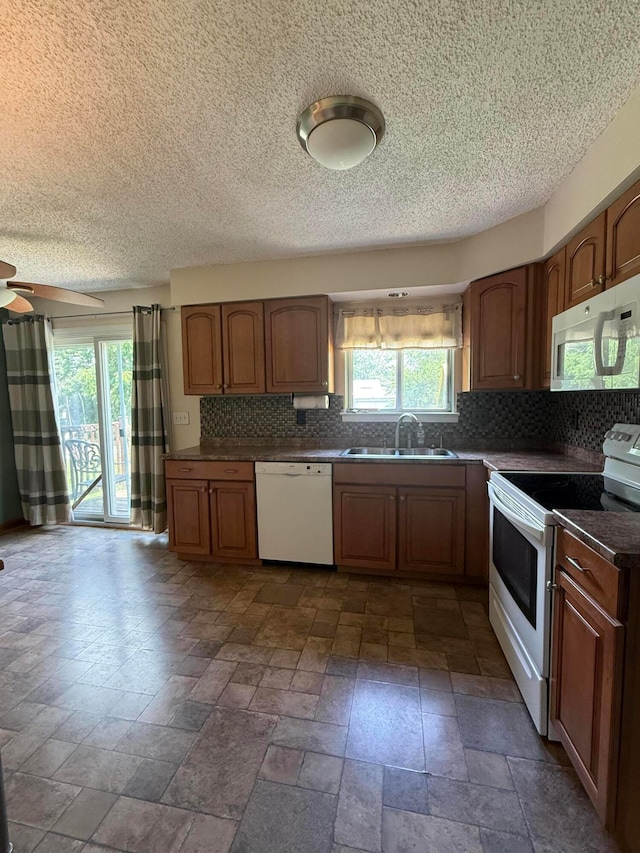 2836 Palisades Ave, Columbus, OH 43207 - kitchen with white appliances, plenty of natural light, decorative backsplash, stone tile flooring, and a textured ceiling