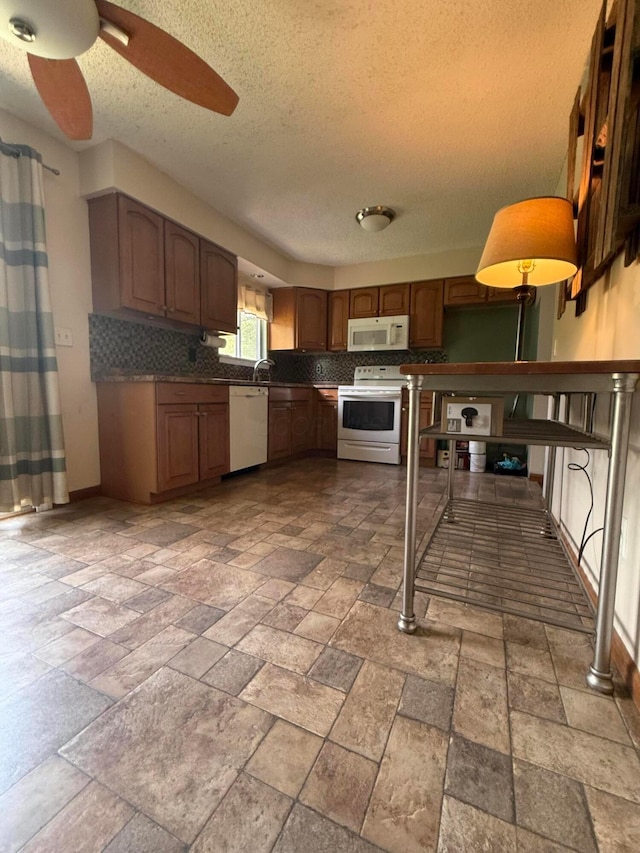 2836 Palisades Ave, Columbus, OH 43207 - kitchen with white appliances, a textured ceiling, stone tile flooring, tasteful backsplash, and ceiling fan