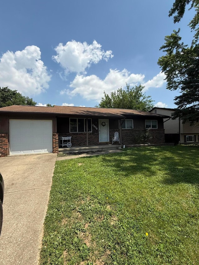 2836 Palisades Ave, Columbus, OH 43207 - view of front of home with brick siding, concrete driveway, an attached garage, a front yard, and covered porch