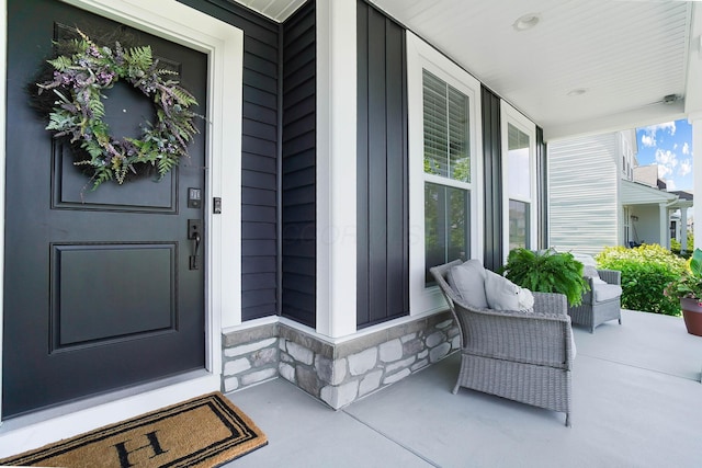 view of exterior entry with covered porch and stone siding