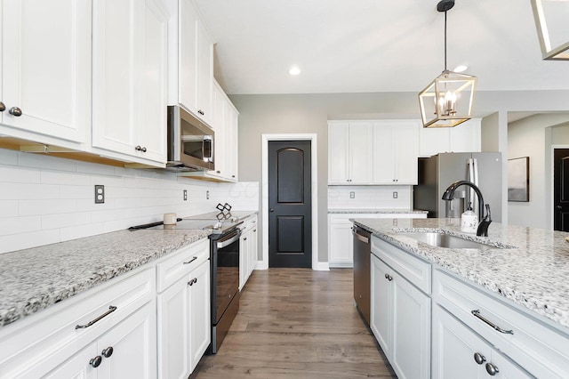 kitchen with stainless steel appliances, a sink, white cabinets, decorative backsplash, and recessed lighting