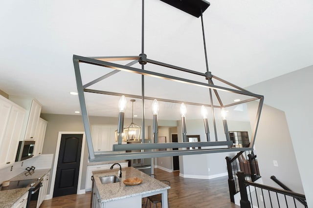 kitchen featuring electric range, a sink, stainless steel microwave, dark wood-type flooring, and white cabinets