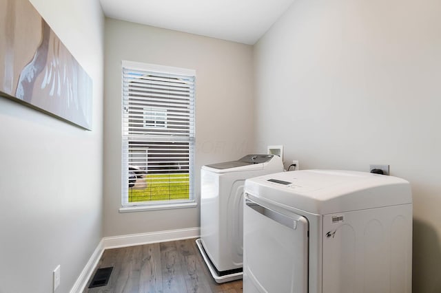 washroom featuring independent washer and dryer, dark wood-style flooring, and baseboards