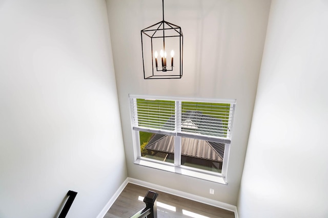 detailed view of a chandelier, baseboards, and wood finished floors