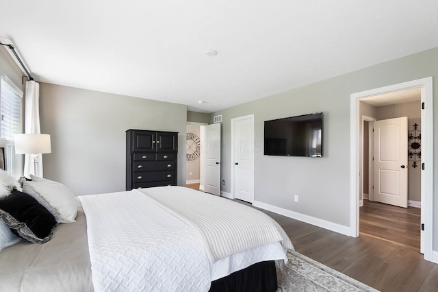 bedroom with baseboards and dark wood finished floors