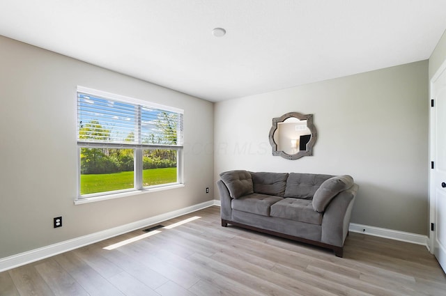 sitting room featuring baseboards and light wood-style floors