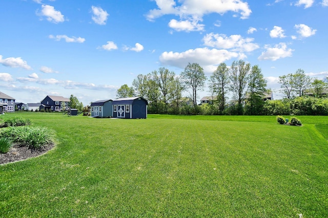 view of green lawn with an outbuilding and a shed