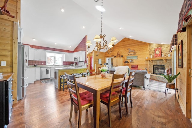 7326 State Route 19 Unit 3, Lots 1-2, Mount Gilead, OH 43338 - dining area featuring wooden walls, a fireplace, vaulted ceiling, wood-type flooring, and a chandelier