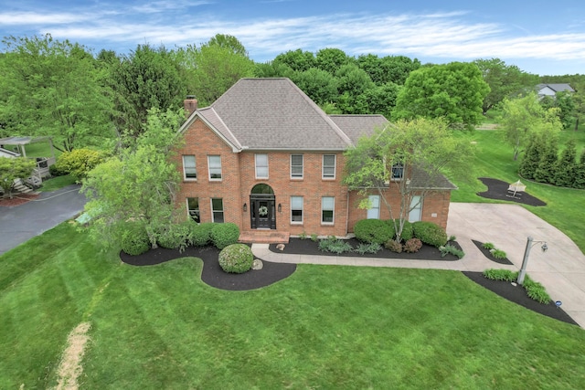 7832 Windsor Ave NW, Canal Winchester, OH 43110 - colonial-style house with a chimney, a front lawn, brick siding, and roof with shingles