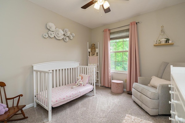 carpeted bedroom with a nursery area and ceiling fan