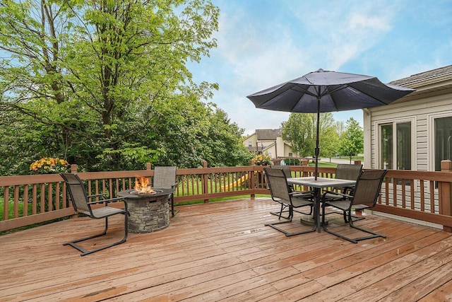 wooden terrace featuring a fire pit and outdoor dining space