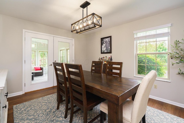 dining area with french doors, dark wood finished floors, baseboards, and a chandelier
