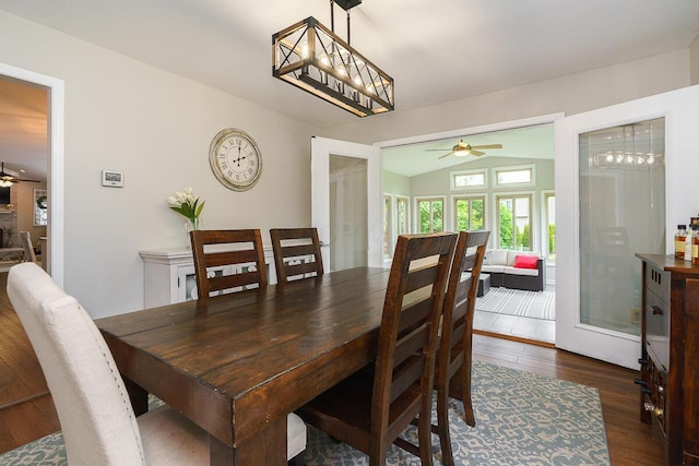 dining room featuring a ceiling fan, dark wood-type flooring, and vaulted ceiling
