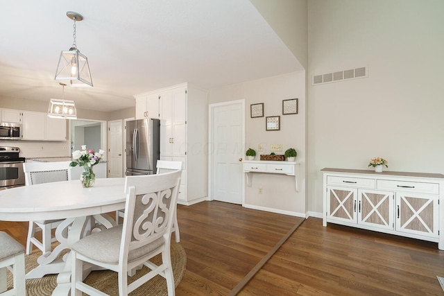 dining space featuring dark wood finished floors and baseboards