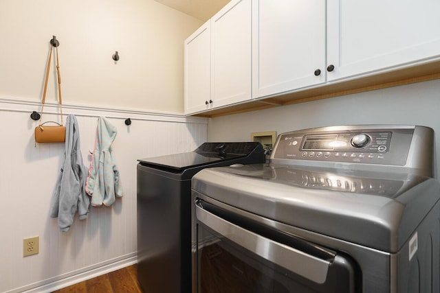washroom featuring cabinet space, washing machine and dryer, and dark wood-style floors