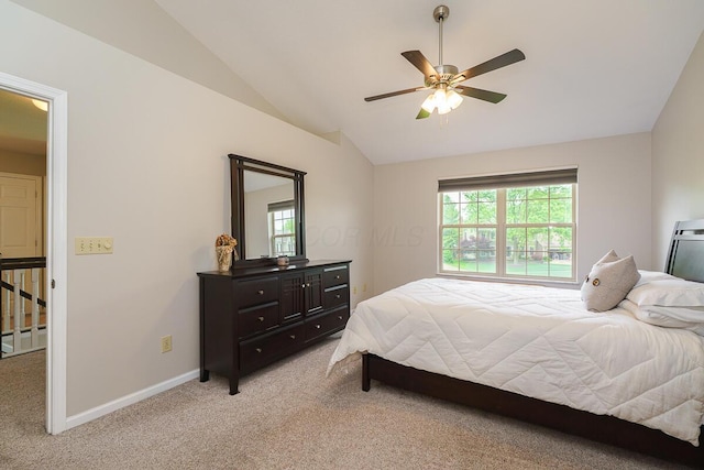bedroom featuring light colored carpet, vaulted ceiling, baseboards, and ceiling fan