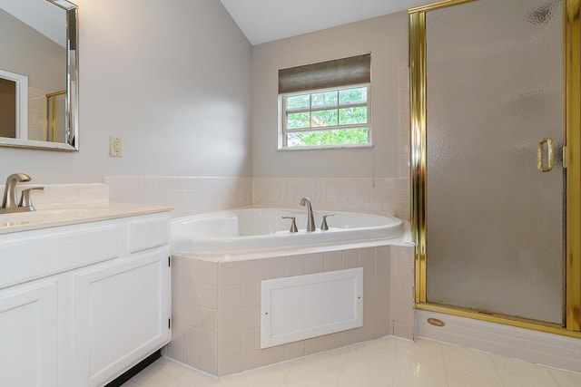 full bathroom featuring tile patterned floors, a stall shower, a garden tub, and vanity