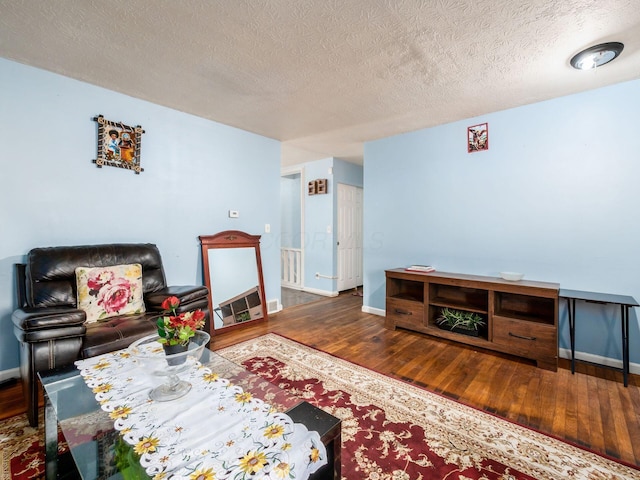 5030 Holbrook Dr, Columbus, OH 43232 - living area featuring wood finished floors, baseboards, and a textured ceiling