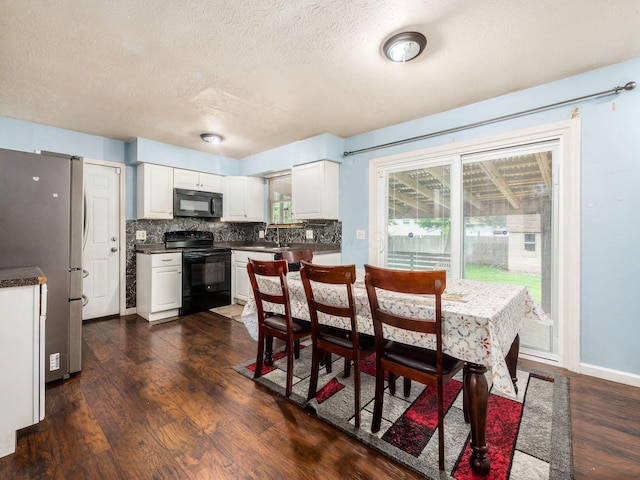 5030 Holbrook Dr, Columbus, OH 43232 - dining room with dark wood finished floors, a textured ceiling, and baseboards