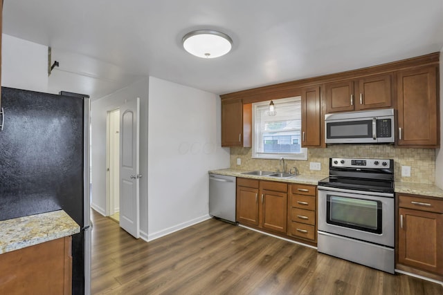 155 N Harris Ave, Columbus, OH 43204 - kitchen featuring stainless steel appliances, a sink, decorative backsplash, dark wood-style floors, and baseboards