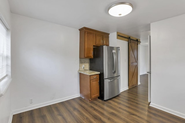 155 N Harris Ave, Columbus, OH 43204 - kitchen featuring freestanding refrigerator, a barn door, dark wood-style flooring, and baseboards