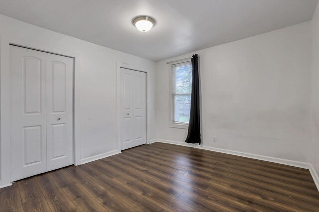 155 N Harris Ave, Columbus, OH 43204 - unfurnished bedroom with multiple closets, baseboards, and dark wood finished floors