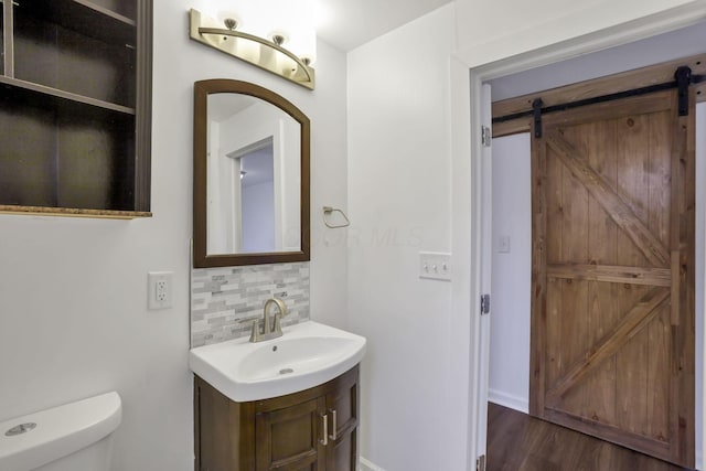 155 N Harris Ave, Columbus, OH 43204 - bathroom with decorative backsplash, toilet, vanity, wood finished floors, and baseboards